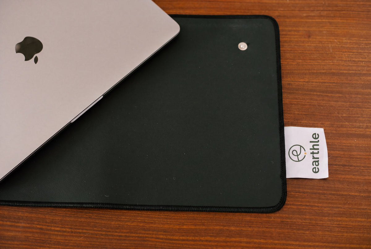 Earthle Erdungs-Schreibtischmatte von oben auf einem Holzschreibtisch, mit Laptop und dem Markenlabel
